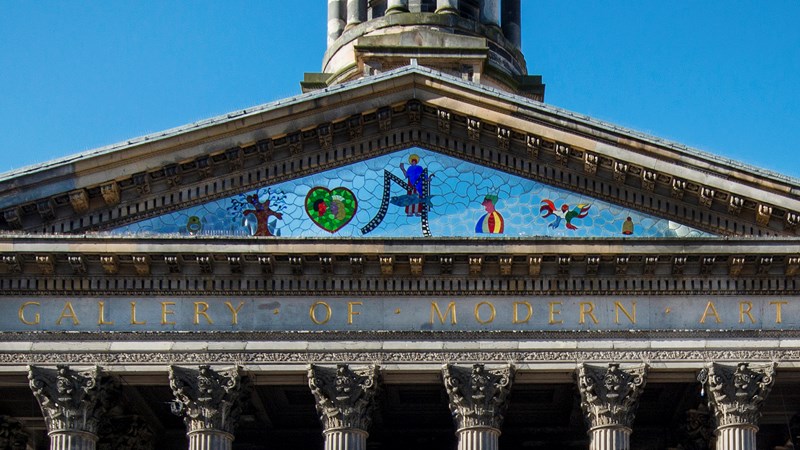 Photograph shows a work by Niki de Saint Phalle - a triangular mosaic - commissioned to sit above the outside entrance.