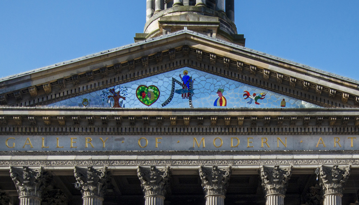Photograph shows a work by Niki de Saint Phalle - a triangular mosaic - commissioned to sit above the outside entrance.