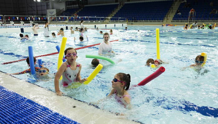 Children playing with pool noodles during a Learn to Swim session at Glasgow Club Tollcross.