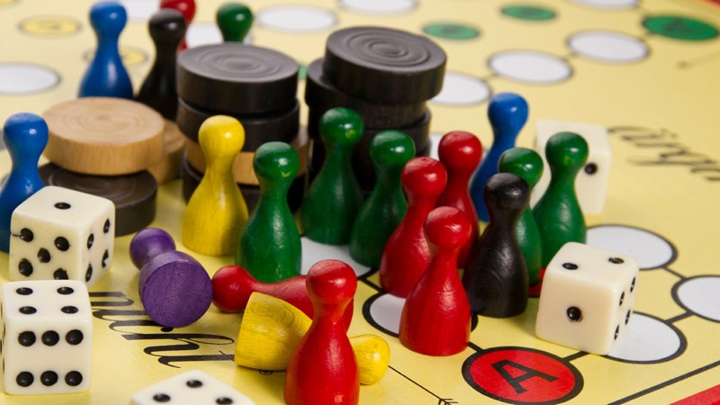 A colourful mix of chess pieces, dice and board game items