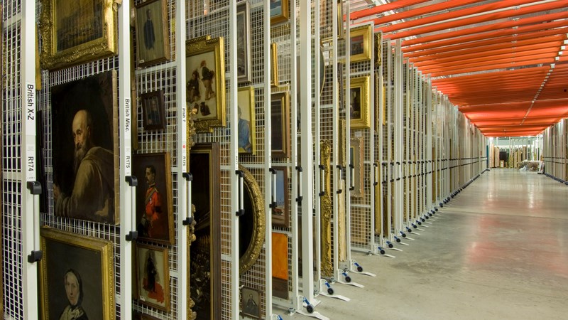 Photograph showing a large store room with racks containing paintings stored here at GMRC.