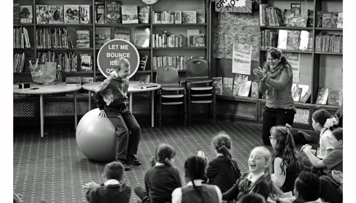 The artist engages a large group of school children. 