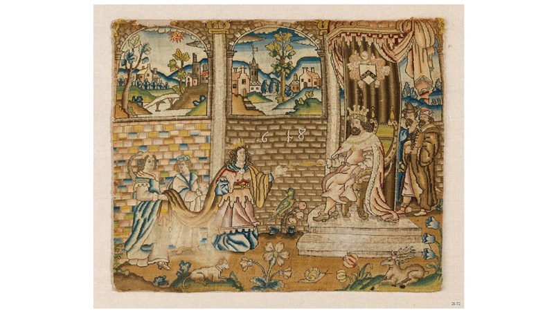 a wide view of an ornate, detailed needlework piece which has figures and scenes within it.