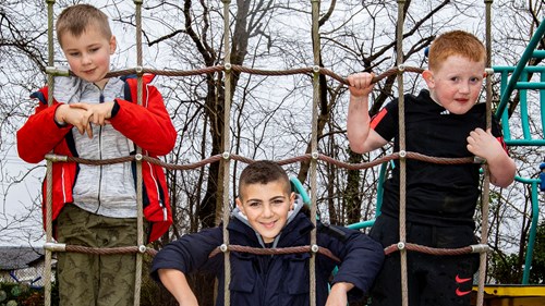 Image of 3 young boys on a climbing net