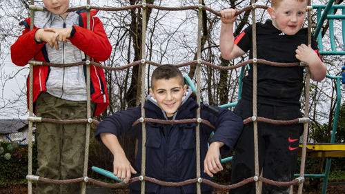 Image of 3 young boys on a climbing net