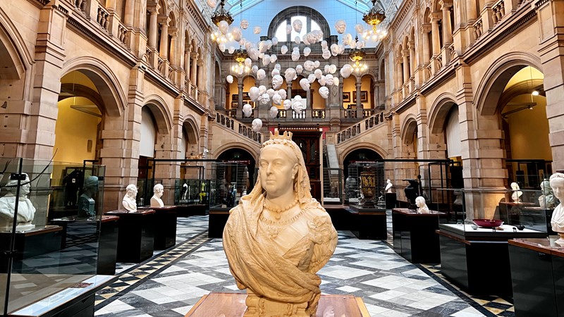 Photograph showing a head and shoulder sculpture of Queen Victoria with a view of the Life gallery inside Kelvingrove Museum