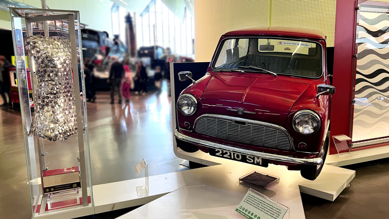 Photograph showing a vintage dress once worn by actress Audrey Hepburn, and a classic Mini