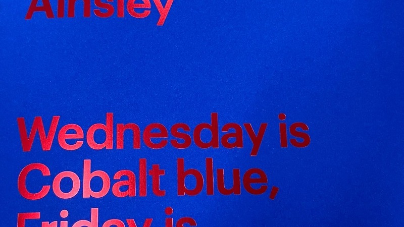 A blue book cover with shiny red writing with the title of the book - Sam Ainsley: Wednesday is Cobalt blue, Friday is Cadmium red