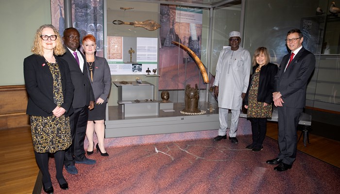 Glasgow Life officials stand beside the Benin bronzes display at Kelvingrove Art Gallery and Museum with delegates from Nigeria's National Commission for Museums and Monuments