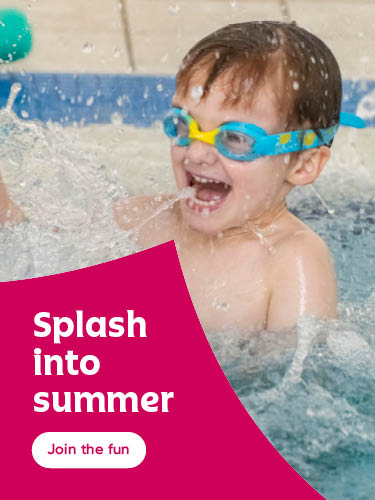 Child wearing blue and yellow swim goggles splashes in a pool, water droplets frozen mid-air. A bright pink banner on the left reads “Splash into summer” with a button below saying “Join the fun.”