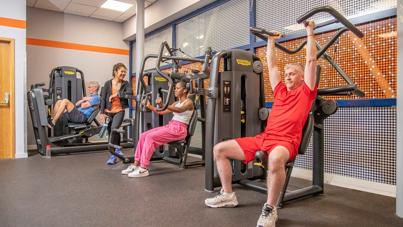 Four people in a Glasgow Club gym using machines during a workout