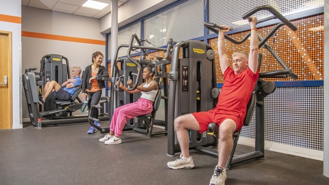 Four people in a Glasgow Club gym using machines during a workout