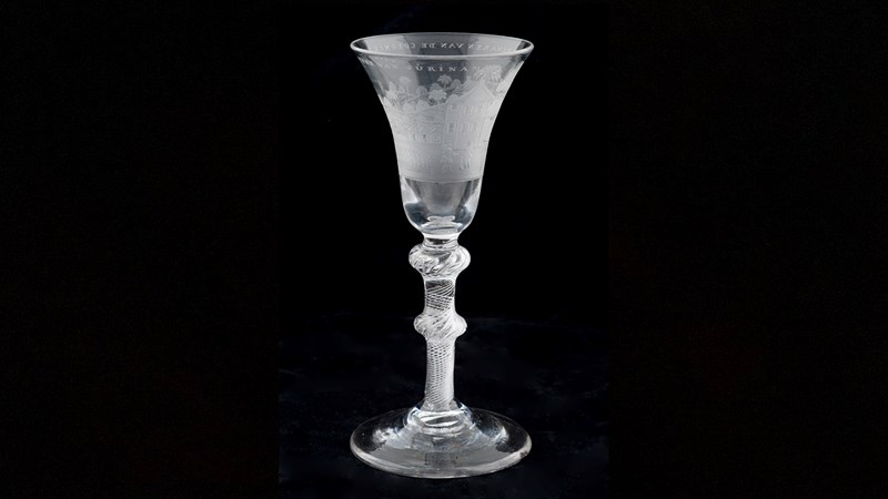 a wine glass with an engraving of a Suriname plantation