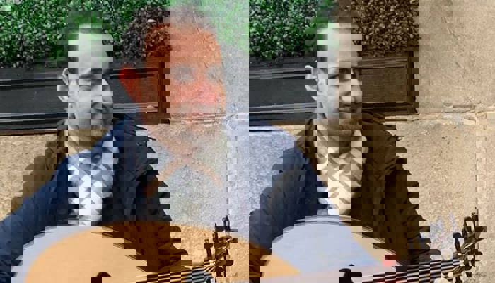 An image of a person standing with a guitar 