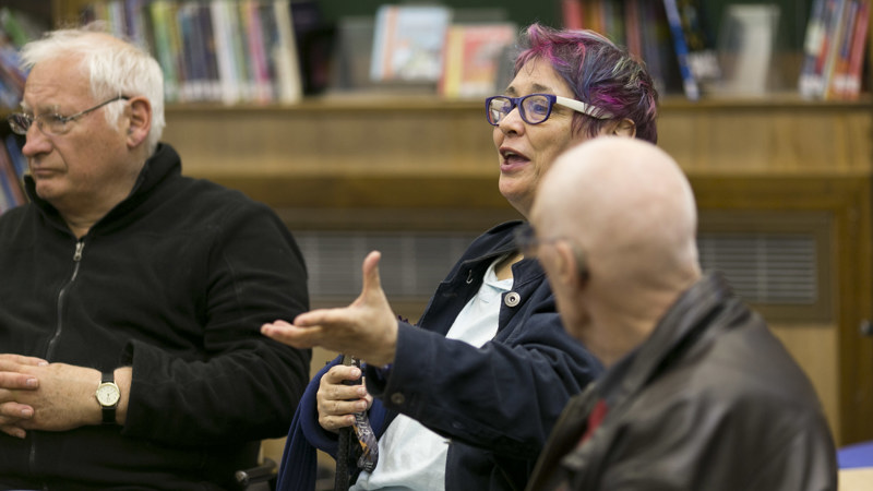 A person talks in a group setting in the libray.