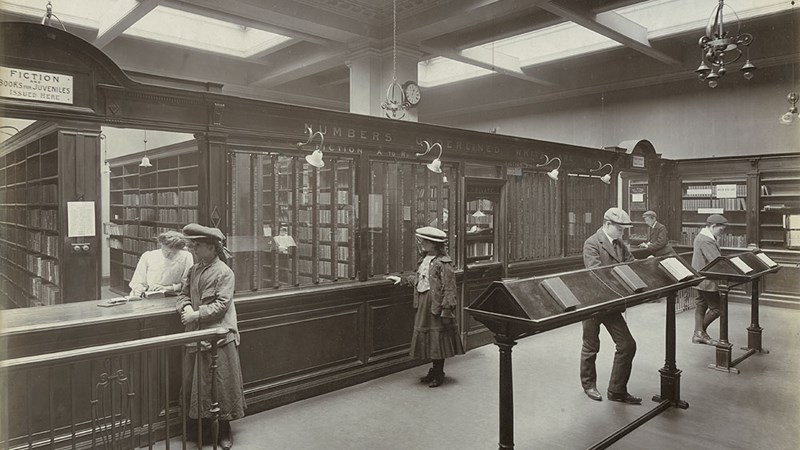 Interior of Anderston District Library featuring six people in Edwardian dress