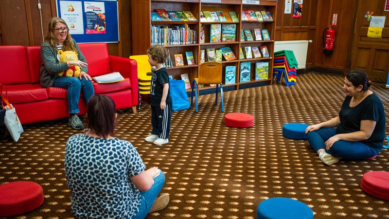 Three people and a child in a Glasgow Life library