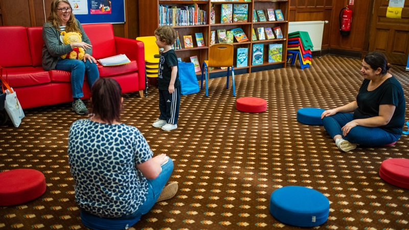 Three people and a child in a Glasgow Life library