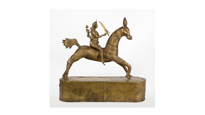 a yellowish metallic sculpture of a sword-wielding figure on horseback.
