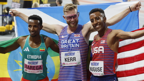 Josh Kerr holding the Scotland flag after winning gold in the 3000 metres at the World Athletics Indoor Championships in Glasgow. He is alongside silver medallist Yared Nuguse from the USA and Selemon Barega from Ethiopia who won bronze.
