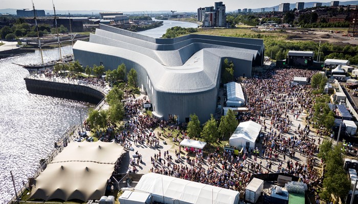 birds eye view of the riverside festival where lots of people are gathered around the museum and the river clyde is to the left of the shot