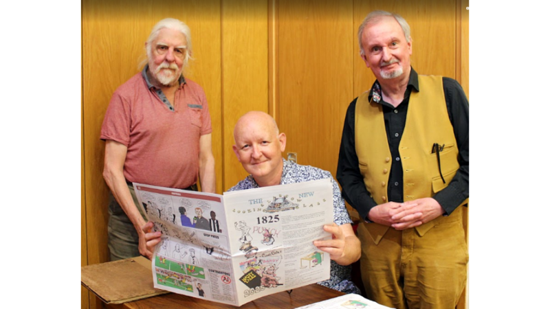 Three men, two standing, one sitting, holding a newspaper