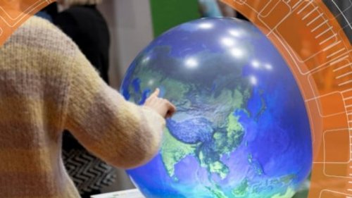 A child is pointing at a globe