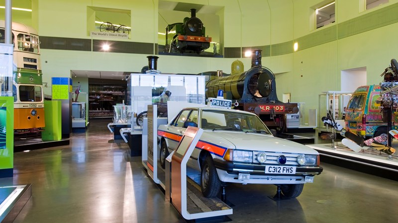 Photograph shows the inside of Riverside museum with a Ford Granada car in the foreground used as a police car.