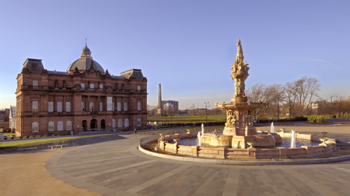 People's Palace and fountain pictured with Glasgow Green in the background. It is sunny