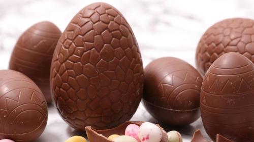 Seven chocolate eggs of varying sizes on a counter