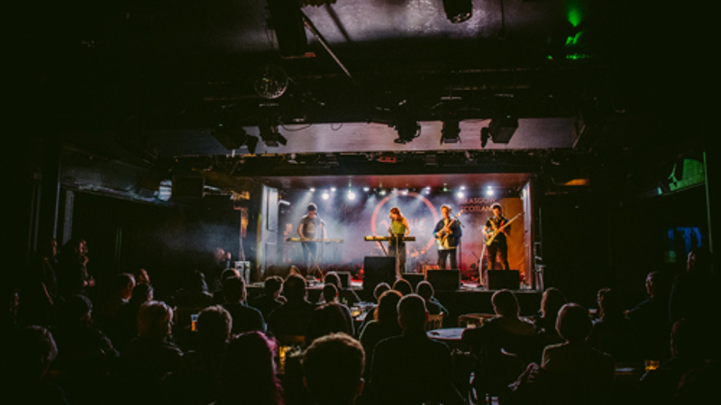 Live music performance on stage at Òran Mór, viewed from the audience.
