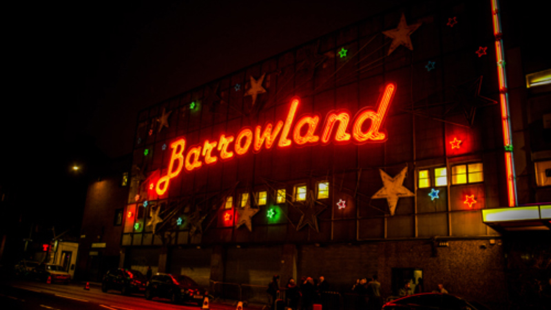 Barrowland Ballroom at night with its famous red neon sign glowing above the street.