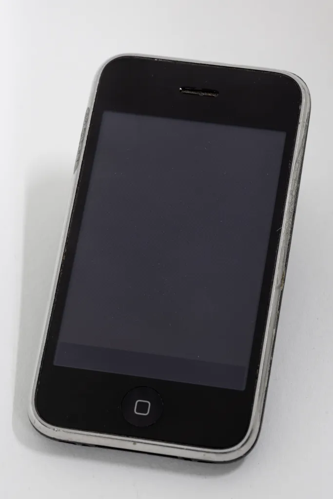 a photograph of an original iPhone on a white background.