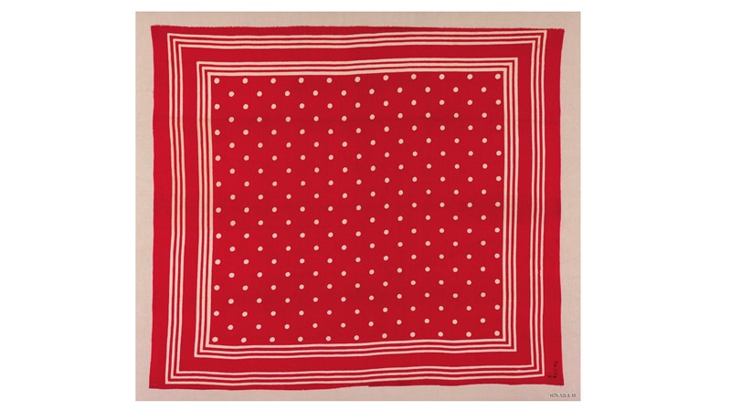 a square red piece of fabric with white outlines and a polka dot pattern in the centre