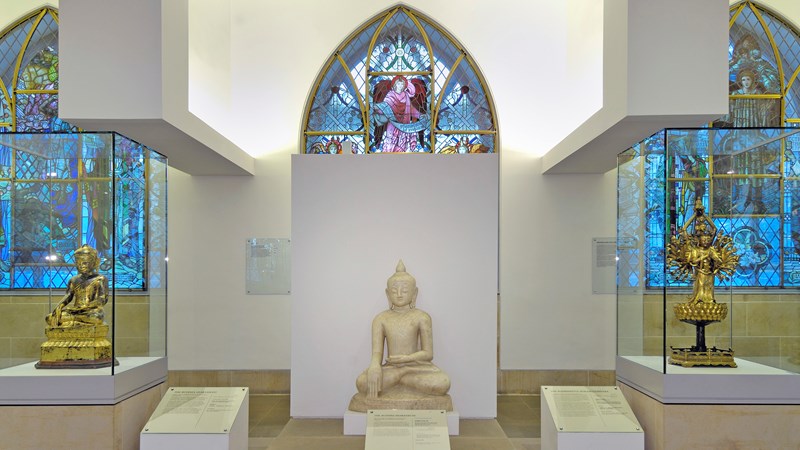 Photograph showing a view inside the Religious Art space, showing a selection of Religious objects and displays on the first floor of St Mungo.