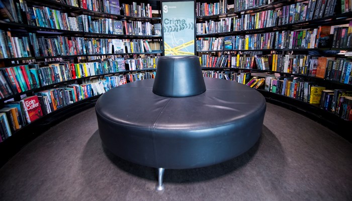 black circular seat with a black circular bookshelf surrounding it