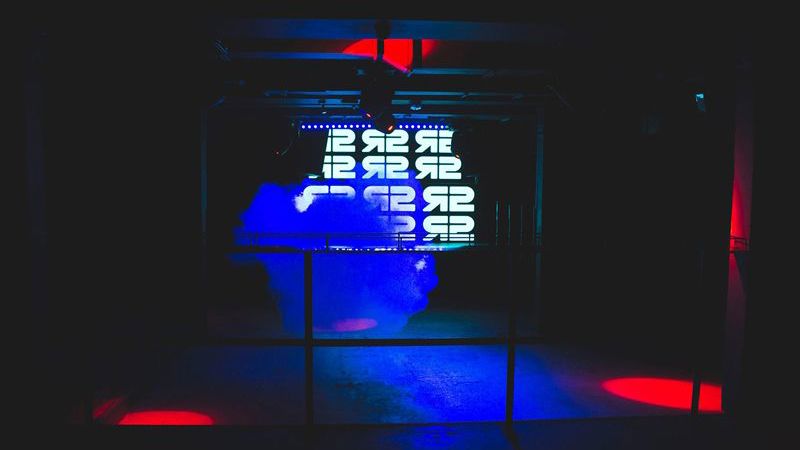 Dark room with blue and red lighting and illuminated display.