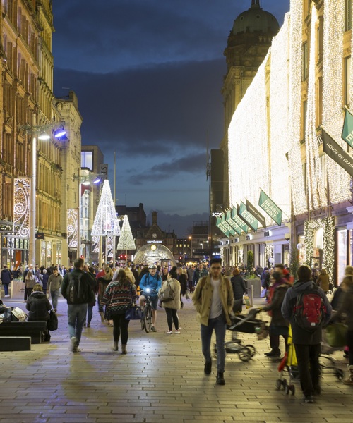 Shoppers walking up Buchanan Street with festive lights in the background