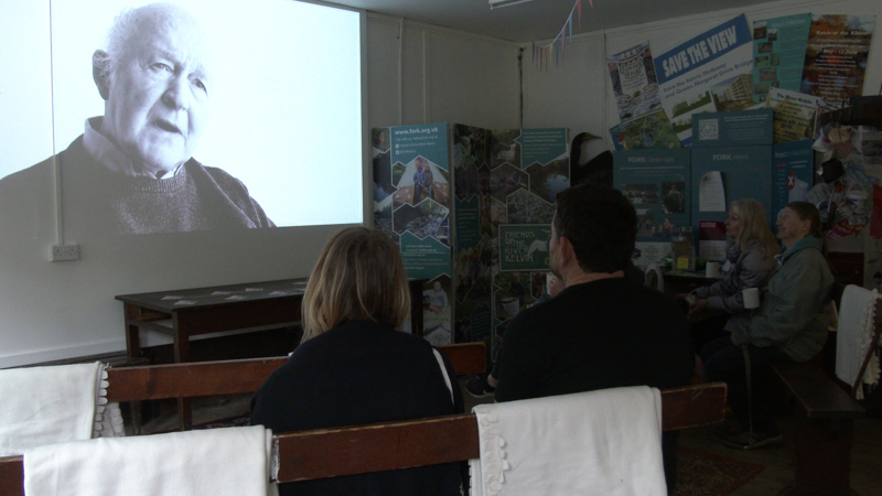 Two people watch a film in black and white. 